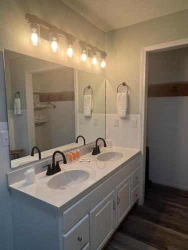 uma casa de banho com 2 lavatórios e um espelho grande em Hotel Marceline em Marceline