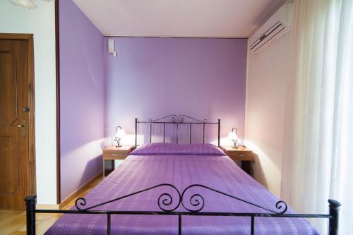 a purple bedroom with a bed with purple sheets at Il Cavaliere in Trapani