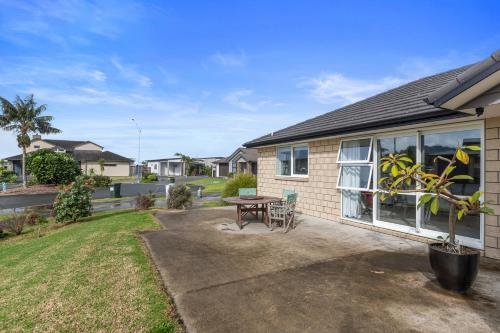 a house with a patio and a table at Shores Getaway - One Tree Point Holiday Home in One Tree Point