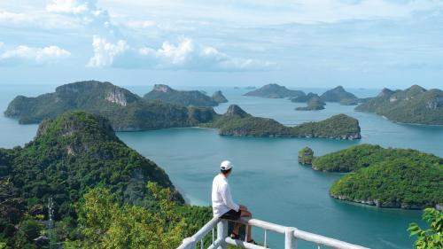 a man standing on a railing looking out over a bay at Holiday Inn Resort Samui Bophut Beach by IHG in Bophut 