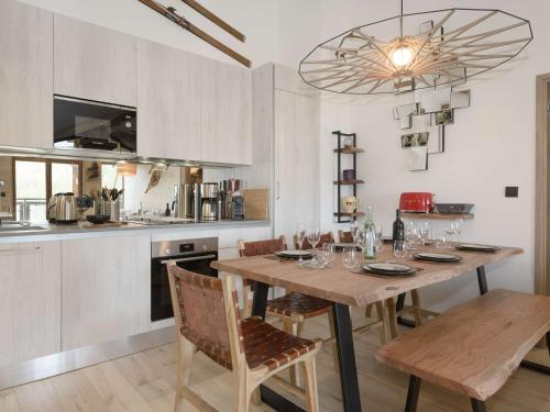 une cuisine avec une table en bois et des chaises ainsi qu'une salle à manger dans l'établissement Appart. 65m² 6 pers - 2 Chambres - Au pied des pistes - Parking et WiFi - FR-1-631-159, à Courchevel