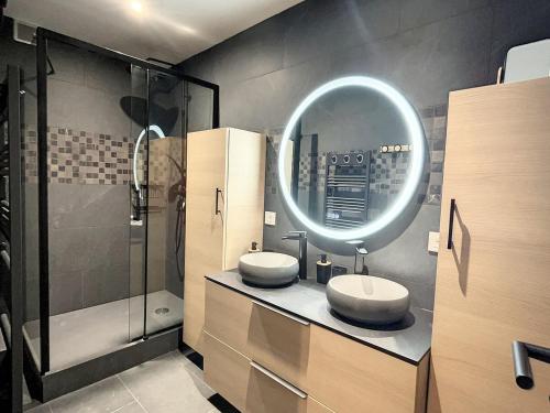 un bagno con due lavandini e uno specchio di Duplex spacieux au pied des pistes avec accès piscine - FR-1-267-255 a Villarembert
