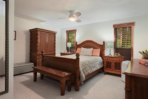 a bedroom with a bed and a dresser and a window at Waikomo Streams 203 in Koloa