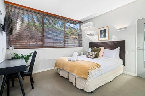 una camera con letto, scrivania e finestra di Alpine Retreat Studio a Queenstown