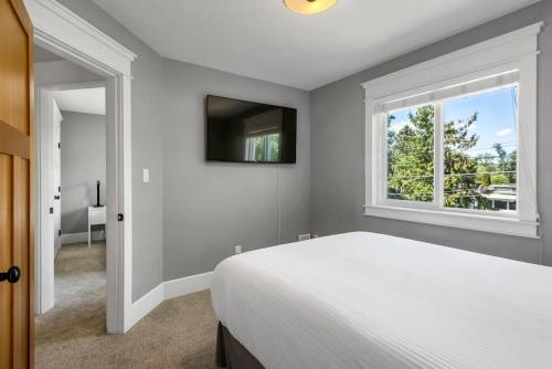 a bedroom with a white bed and a window at Comfort and joy in Prince George