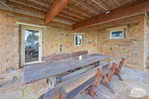 a large wooden bench on the outside of a stone wall at Bridgey Escape in Cape Bridgewater