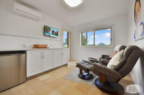 a living room with a chair and a kitchen at Bridgey Escape in Cape Bridgewater