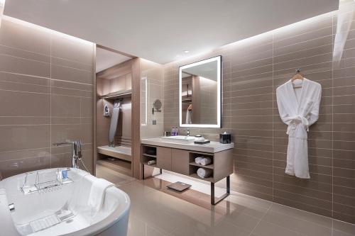 y baño con bañera, lavamanos y bañera. en Holiday Inn Tianjin Wuqing, an IHG Hotel, en Wuqing