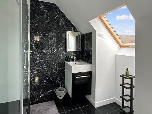 a black and white bathroom with a sink and a mirror at Sealladh Apartment - Ukc6792 in Port Appin