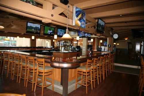 a bar in a restaurant with chairs and televisions at Lake Lawn Resort in Delavan