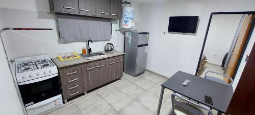 a small kitchen with a stove and a refrigerator at Complejo Las3B in General Roca