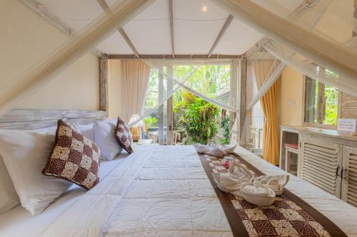 烏布的住宿－巴厘島烏布阿拉姆普拉切塔旅館，一间卧室设有一张大床和一个大窗户
