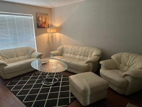 a living room with two couches and a table at Lovely 1-Bedroom Townhome with Nice Amenities in Houston