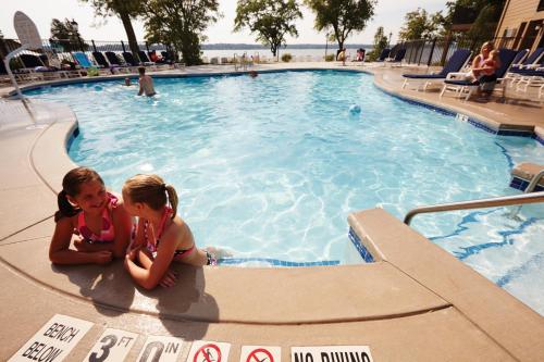two young girls sitting next to a swimming pool at Lake Lawn Resort in Delavan