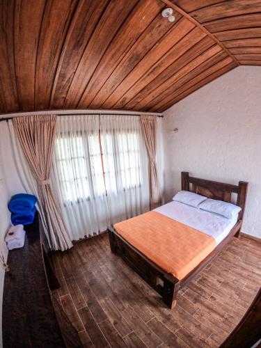 a bedroom with a bed and a wooden ceiling at Ecohotel Entrebosques in Salento