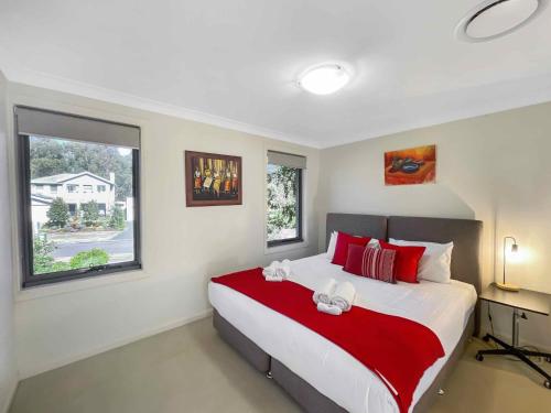 a bedroom with a large bed with red and white pillows at Kaya in Rothbury