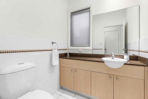 a bathroom with a sink and a toilet and a mirror at Kaya in Rothbury