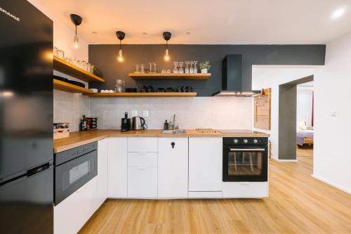 a kitchen with white cabinets and black appliances at Serenity in Pribylina