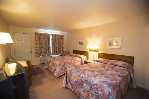 a hotel room with two beds and a window at Motel Vaudreuil in Vaudreuil-Dorion
