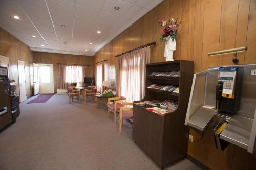 a large room with wooden walls and tables and chairs at Motel Vaudreuil in Vaudreuil-Dorion