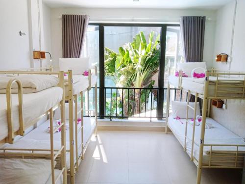 a dorm room with bunk beds and a balcony at Bed Station Hostel & Pool Bar Hội An " Former Sunflower" in Hoi An
