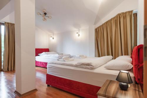 two beds in a room with red and white at Lux House with own parking in Skopje in Skopje