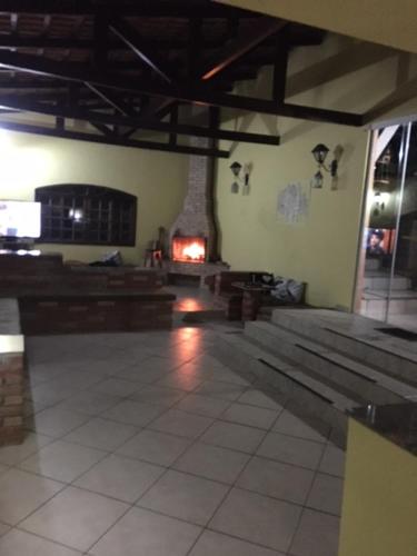 a room with wooden benches and a fireplace in a building at Recanto dos Passáros Penedo RJ in Penedo