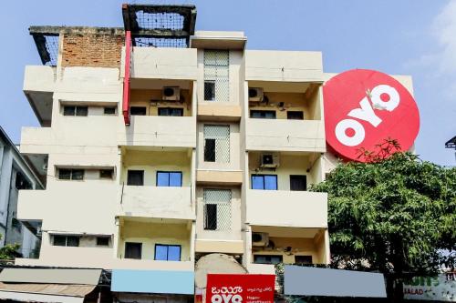 海得拉巴的住宿－Flagship Happy Guest House near LV Prasad eye Hospital，一座高大的公寓楼,上面有红色的标志