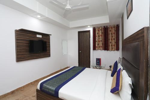 una camera con letto e TV a parete di Collection O 10795 Hotel Nandgiri a Nuova Delhi