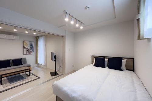 東京にあるtoggle BUNKYO KORAKUENのベッドルーム(大きな白いベッド1台、ソファ付)