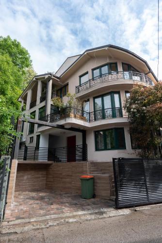 a large white house with a balcony on a street at Lux House with own parking in Skopje in Skopje