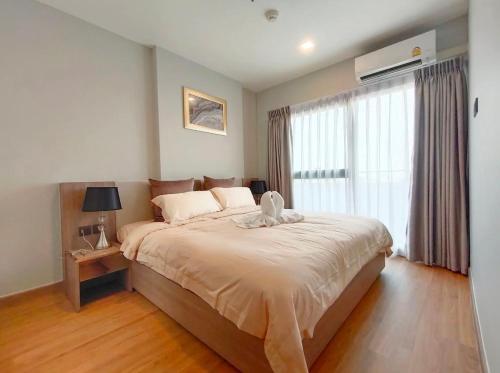 ein Schlafzimmer mit einem großen Bett und einem Fenster in der Unterkunft Astra sky river 两室豪华公寓 in Chiang Mai