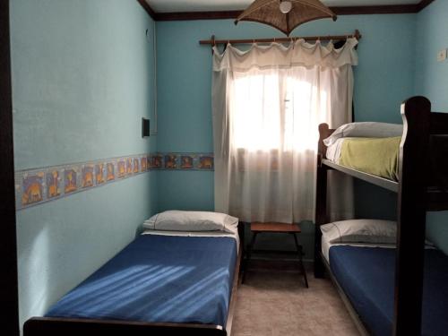 a room with two bunk beds and a window at Cabaña Los Lirios in Huerta Grande