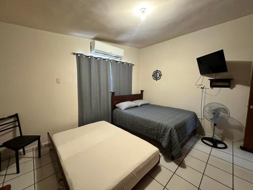 um quarto com uma cama e uma televisão em Casa HuasteValles em Ciudad Valles