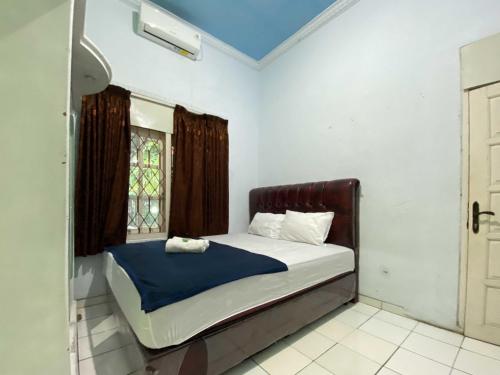 Un pat sau paturi într-o cameră la Guest House Hj Muriyah Syariah Slawi Mitra RedDoorz
