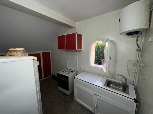 cocina con fregadero, fogones y ventana en La pivoine jaune, en Ifrane