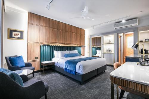 Una habitación de hotel con una cama, un escritorio y sillas. en Powerhouse Hotel Tamworth by Rydges, en Tamworth