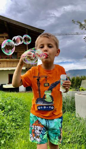 a young boy holding up bubbles in his mouth at Bioberghof Rohr in Fieberbrunn