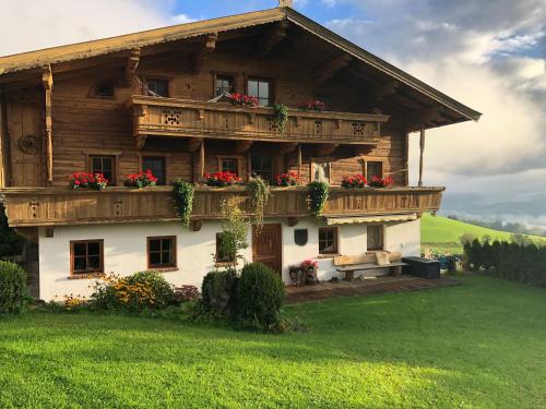 a wooden house with flowers on the balcony at Bioberghof Rohr in Fieberbrunn