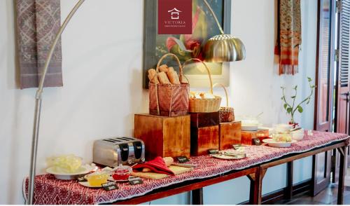 a table with plates of food and a toaster at Victoria XiengThong Palace in Luang Prabang