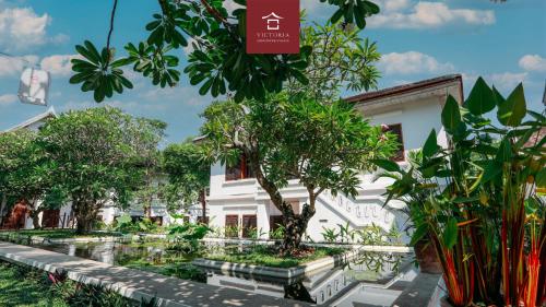 a building with trees in front of it at Victoria XiengThong Palace in Luang Prabang