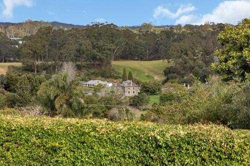 a house in the middle of a field of trees at Enchanted Retreat - Kerikeri Holiday Home in Kerikeri