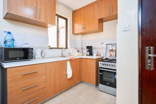 a kitchen with wooden cabinets and a microwave at City view luxury Suites in Nairobi