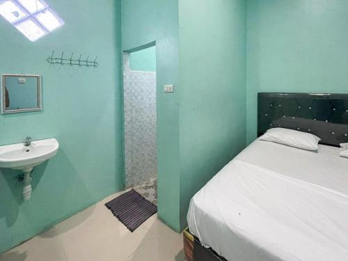 łazienka z łóżkiem i umywalką w obiekcie Antony Homestay near Pantai Pasir Putih Parbaba Mitra RedDoorz w mieście Pangururan