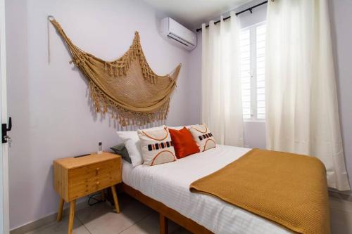 Un dormitorio con una cama con paredes blancas y una ventana en Casa Marilina Aguadilla w/ Pool en Aguadilla