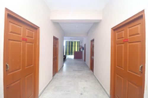 a hallway with two brown doors and a hallway with a room at OYO Flagship 18570 Hotel Jazz in Lālewāl