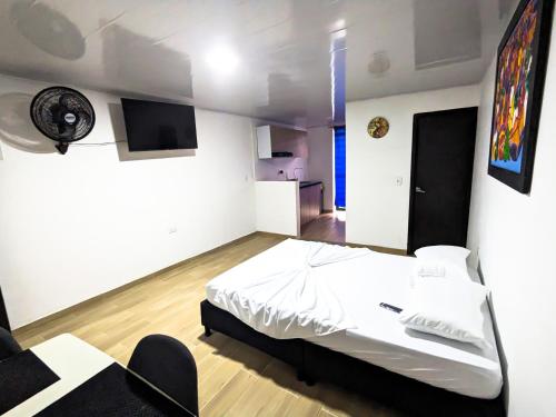 a bedroom with a bed and a desk and a tv at Apartaestudio para estrenar La Quinta in Ibagué