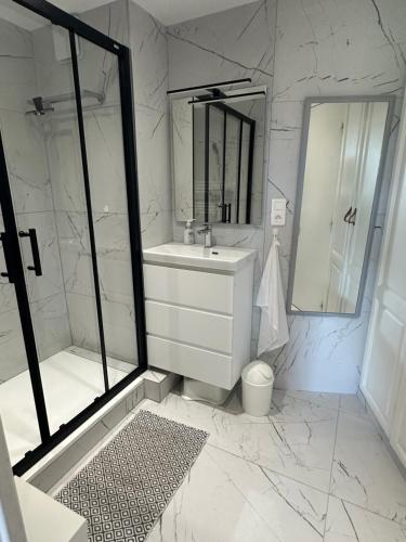 a white bathroom with a sink and a shower at Village Pierre et vacances Cap Estérel centre FH007 jardin privatif clôturé , vue mer in Agay - Saint Raphael