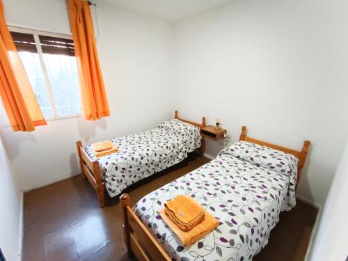 2 camas individuales en una habitación con ventana en Depto Los Toneles en Mendoza