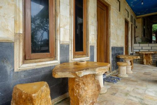 a room with two wooden tables and two stools at Hotel Kampoeng Drini RedPartner in Brono